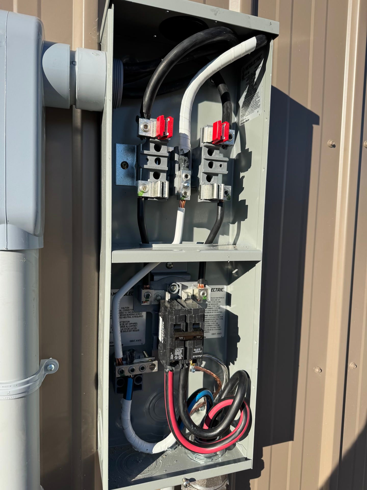 An open electrical disconnect enclosure showing fuses and wiring landed neatly.